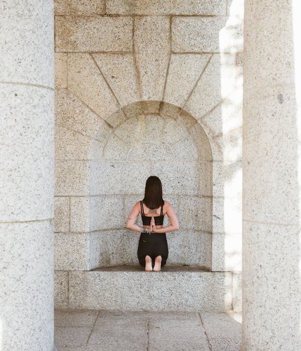 Woman in a focused outdoor yoga pose.